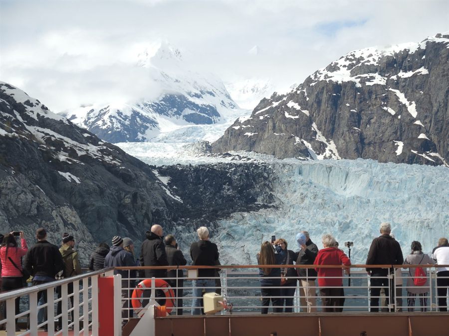 Passengers watching a glacier from a ship deck